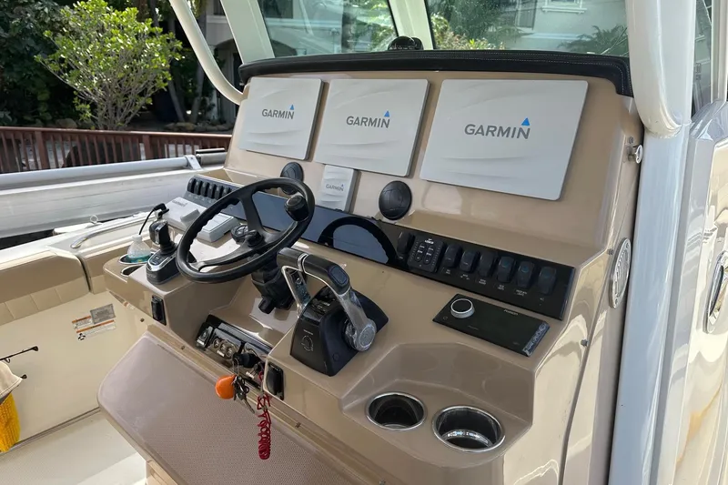 Slide: The Image of 2019 Sailfish 360 CC boat dashboard with Garmin navigation displays and steering wheel. - 19