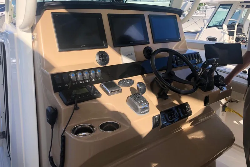 Slide: The Image of Control panel of 2019 Sailfish 360 CC boat with steering wheel and navigation screens. - 21