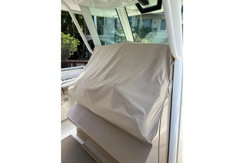 Slide: The Image of Covered console area of a 2019 Sailfish 360 CC boat, showcasing protective cover. - 23