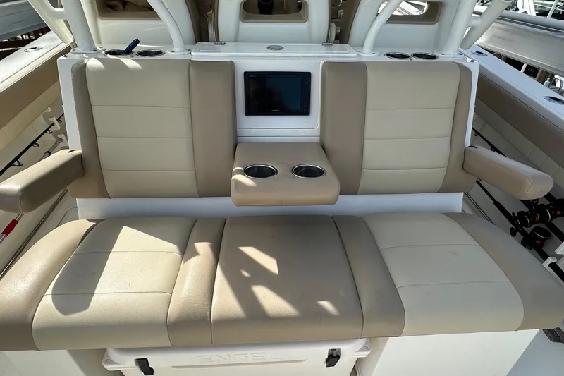 Slide: The Image of 2019 Sailfish 360 CC boat seating with beige cushions and cup holders. - 29