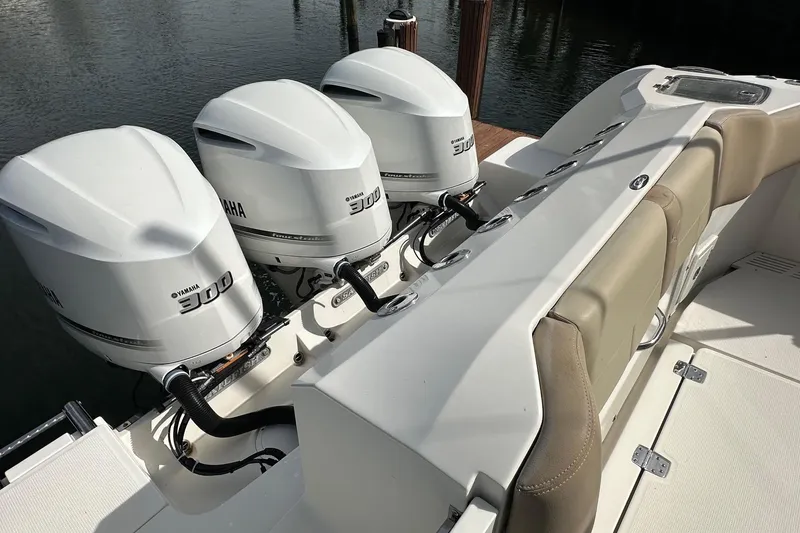 Slide: The Image of 2019 Sailfish 360 CC boat with triple Yamaha 300 engines, docked by the water. - 31