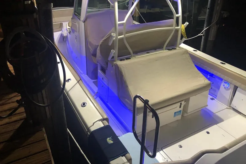 Slide: The Image of 2019 Sailfish 360 CC boat with illuminated deck and covered seating at night. - 35