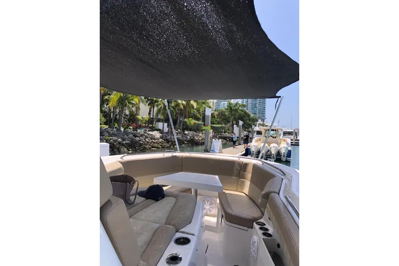 Slide: The Image of 2019 Sailfish 360 CC boat interior with seating and canopy at marina. - 7