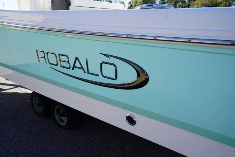 Slide: The Image of 2023 Robalo 246 Cayman boat with sleek turquoise and white design. - 12