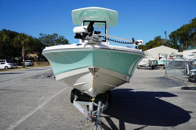Slide: The Image of 2023 Robalo 246 Cayman boat on trailer in sunny marina setting. - 4