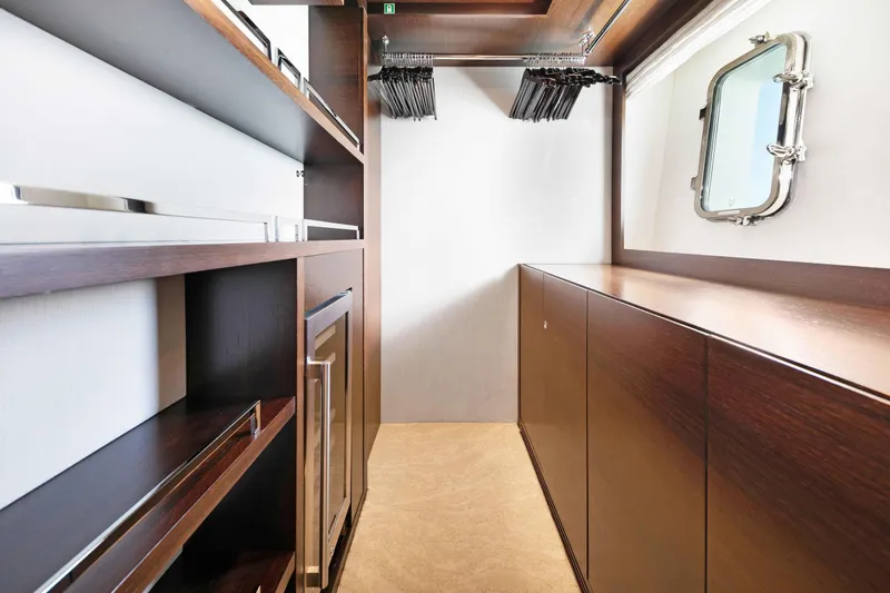 Slide: The Image of Luxurious Master bedroom closet of 2012 Azimut Grande 32M yacht with elegant wood cabinetry and porthole. - 37