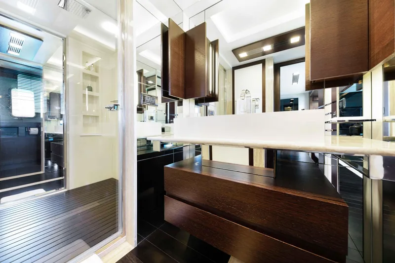 Slide: The Image of Luxurious Main Deck VIP bathroom with walk-through shower and doubles as a day head interior on 2012 Azimut Grande 32M yacht, featuring modern wood cabinetry. - 55
