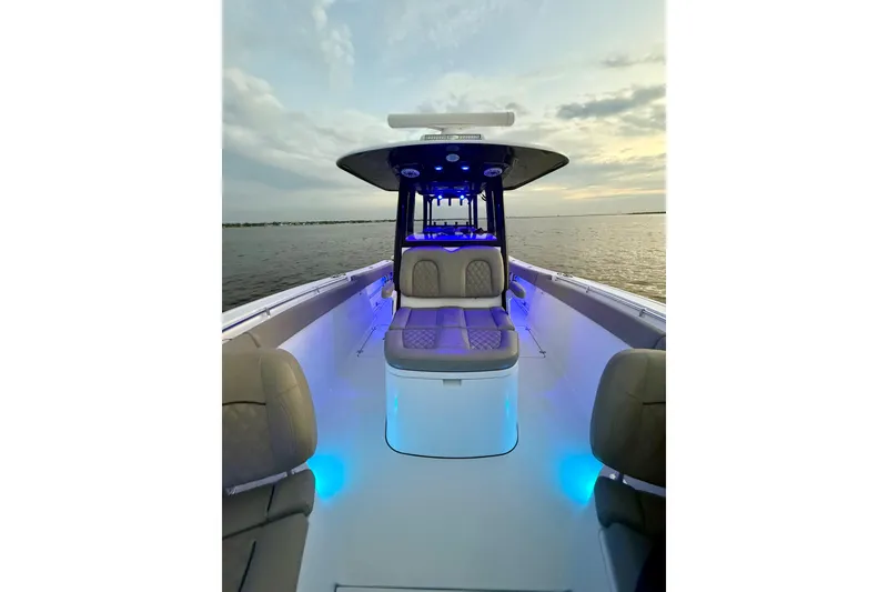 Slide: The Image of 2022 Sportsman Open 322 Center Console boat with blue LED lights at sunset. - 15