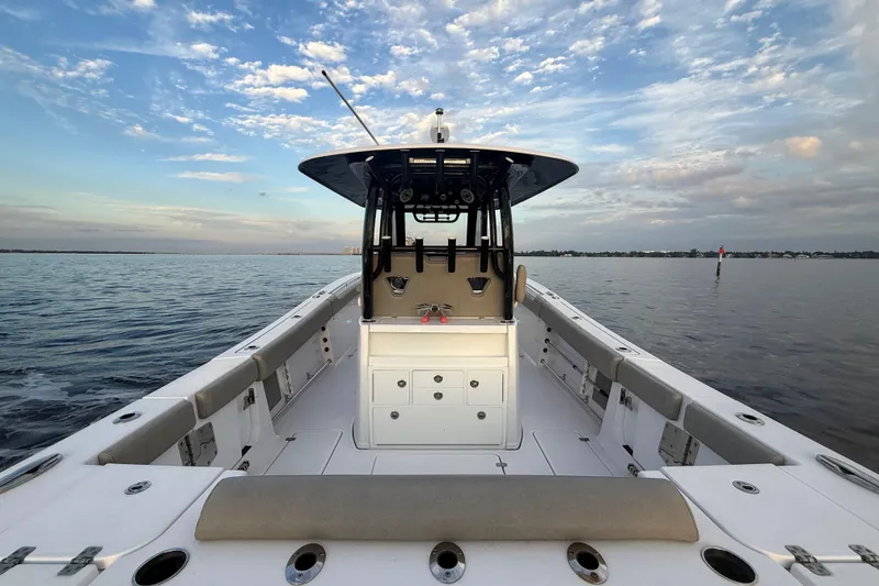 Slide: The Image of 2022 Sportsman Open 322 Center Console boat on calm water under a partly cloudy sky. - 16