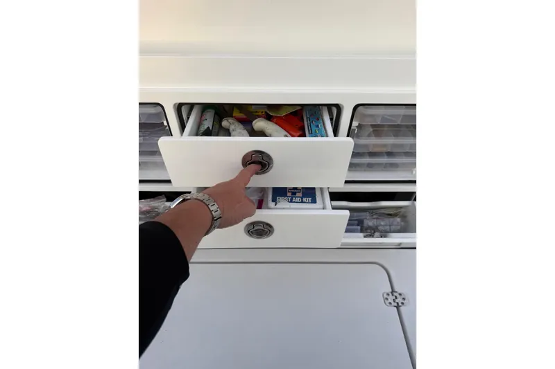 Slide: The Image of Hand opening storage drawer on 2022 Sportsman Open 322 Center Console boat. - 19