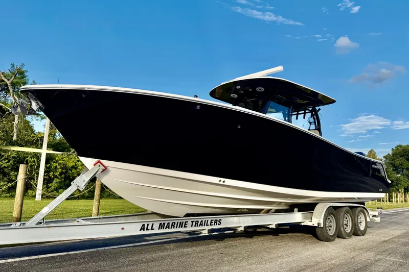 Slide: The Image of 2022 Sportsman Open 322 Center Console boat on trailer under clear blue sky. - 23