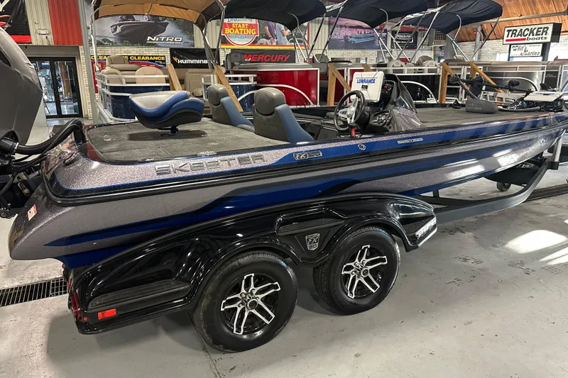 Slide: The Image of 2016 Skeeter FX20 Limited Edition boat in showroom, featuring sleek design and dual-axle trailer. - 2