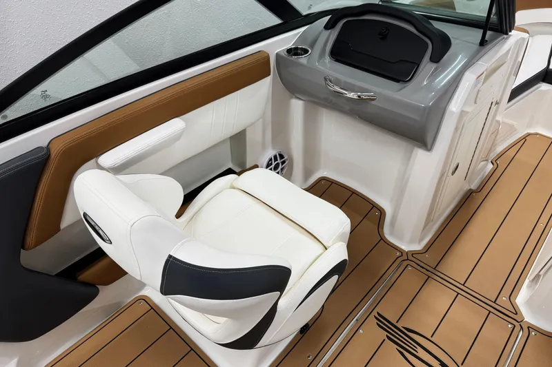 Slide: The Image of 2026 Chaparral 21 SSi boat interior with white and brown seating, modern dashboard, and wood-style flooring. - 17