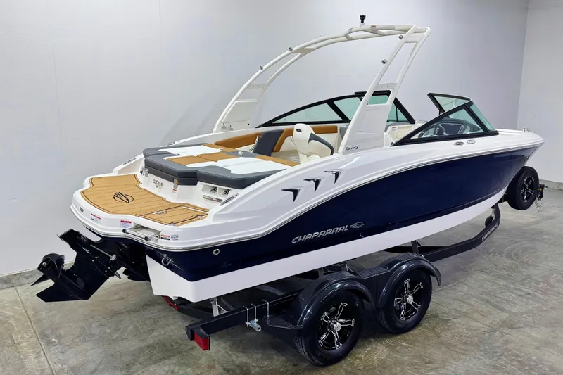 Slide: The Image of 2026 Chaparral 21 SSi boat on trailer, sleek design, white and navy blue exterior. - 2