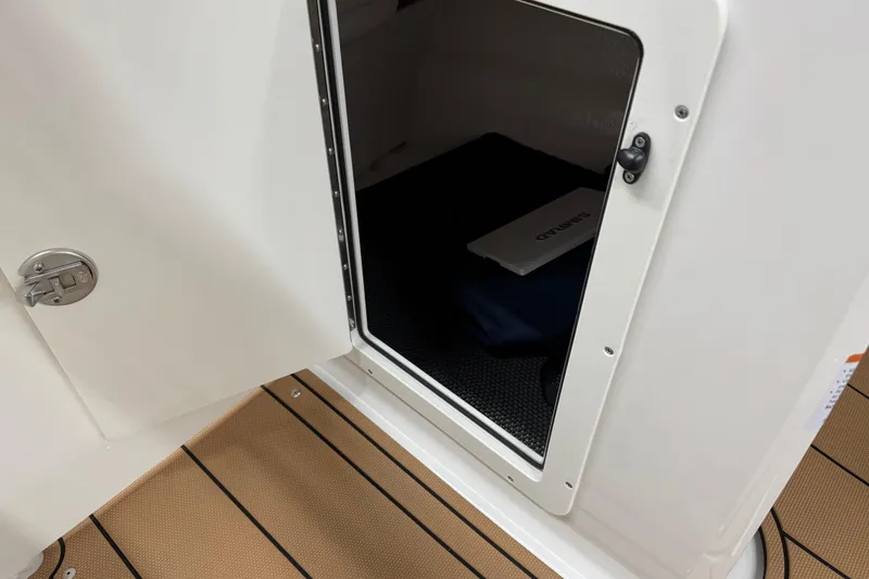 Slide: The Image of Open storage compartment on 2026 Chaparral 21 SSi boat, featuring teak flooring. - 23
