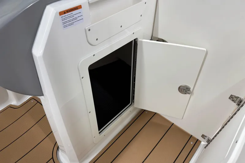 Slide: The Image of 2026 Chaparral 21 SSi boat storage compartment with open door, showcasing interior space. - 24