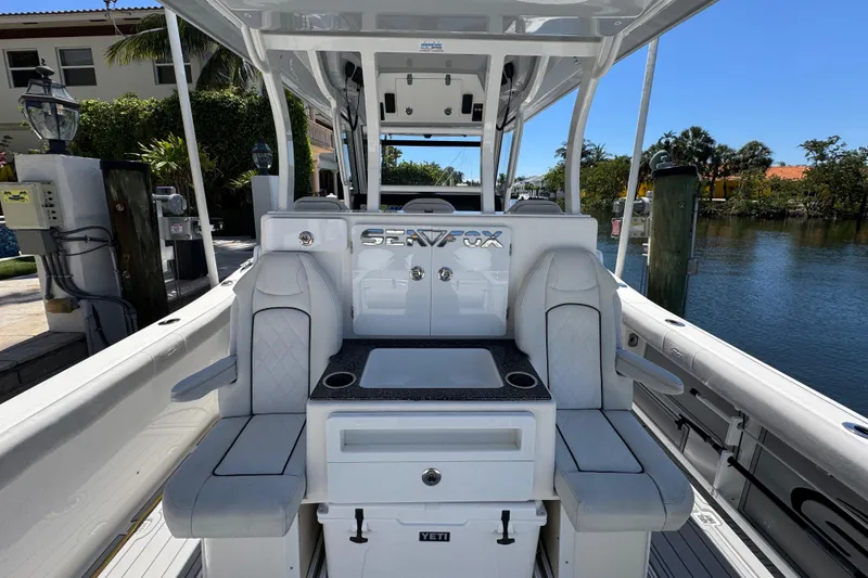 Slide: The Image of 2020 Sea Fox 368 Commander boat interior with seating and console, docked by a waterfront. - 15