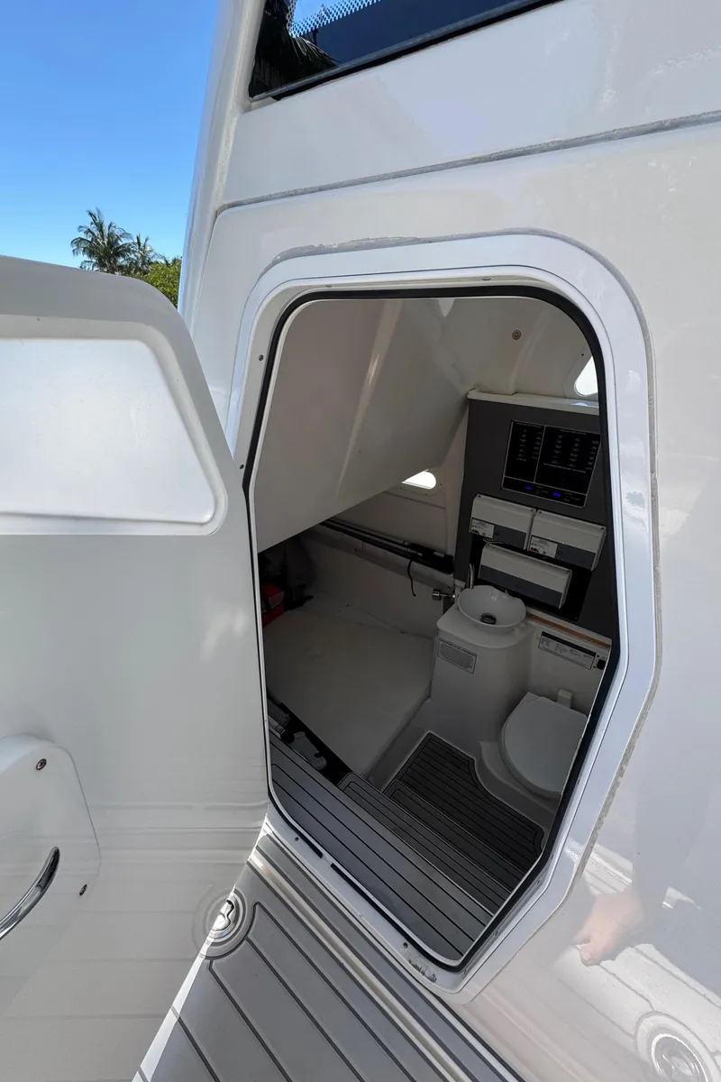 Slide: The Image of 2020 Sea Fox 368 Commander boat interior with open door, showing compact bathroom facilities. - 24