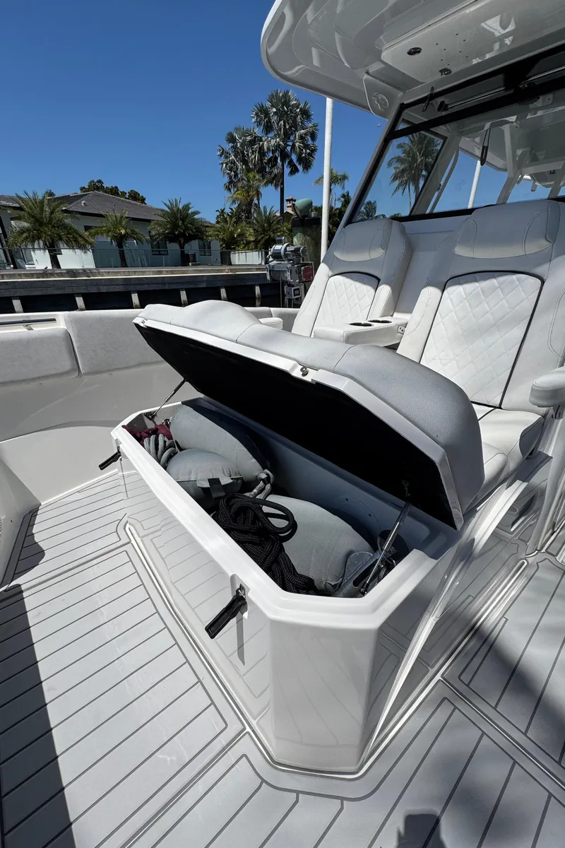 Slide: The Image of 2020 Sea Fox 368 Commander boat with open storage compartment, docked near palm trees. - 28