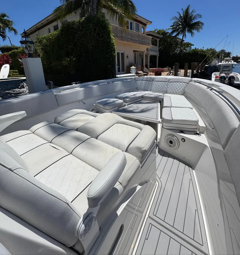 Slide: The Image of 2020 Sea Fox 368 Commander boat with luxurious seating, docked near a waterfront home. - 30