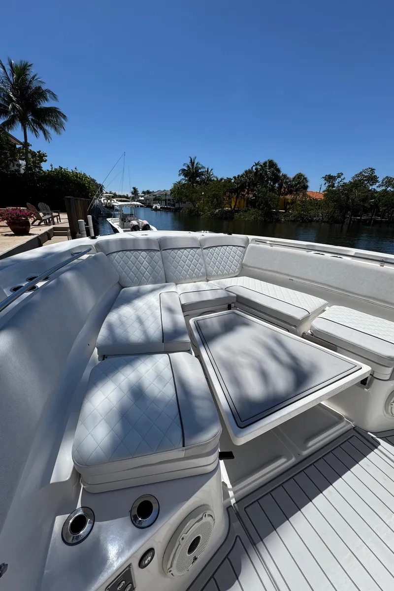 Slide: The Image of 2020 Sea Fox 368 Commander boat with luxurious seating, docked by a scenic waterfront. - 31