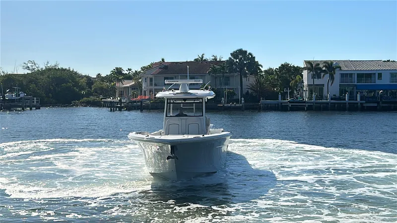 Slide: The Image of 2020 Sea Fox 368 Commander boat cruising on a sunny waterfront with houses in the background. - 42
