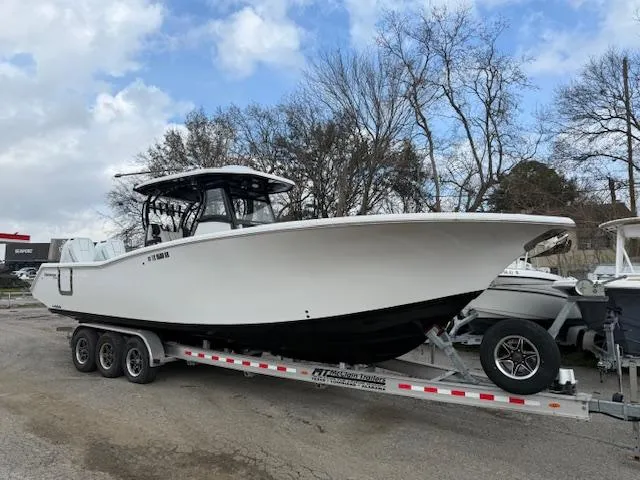 The Image of 2024 Tidewater 320 CC Adventure boat on a trailer, parked outdoors. - 0
