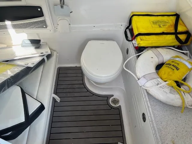 Slide: The Image of 2024 Tidewater 320 CC Adventure boat interior with toilet, life preserver, and safety equipment. - 12