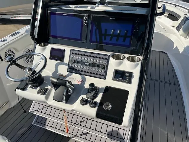 Slide: The Image of 2024 Tidewater 320 CC Adventure boat console with dual screens and controls. - 6