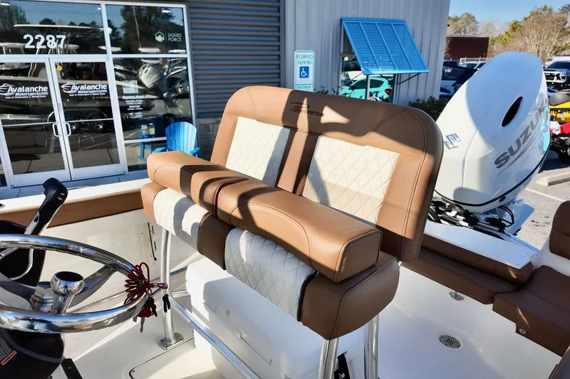 Slide: The Image of 2026 Pioneer 202 Islander boat interior with tan and white seating, Suzuki engine visible. - 11