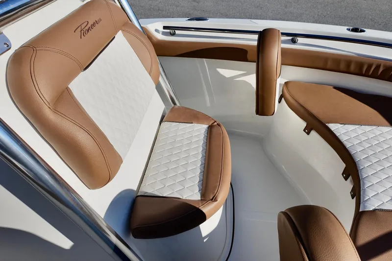 Slide: The Image of 2026 Pioneer 202 Islander boat interior with tan and white cushioned seating. - 12