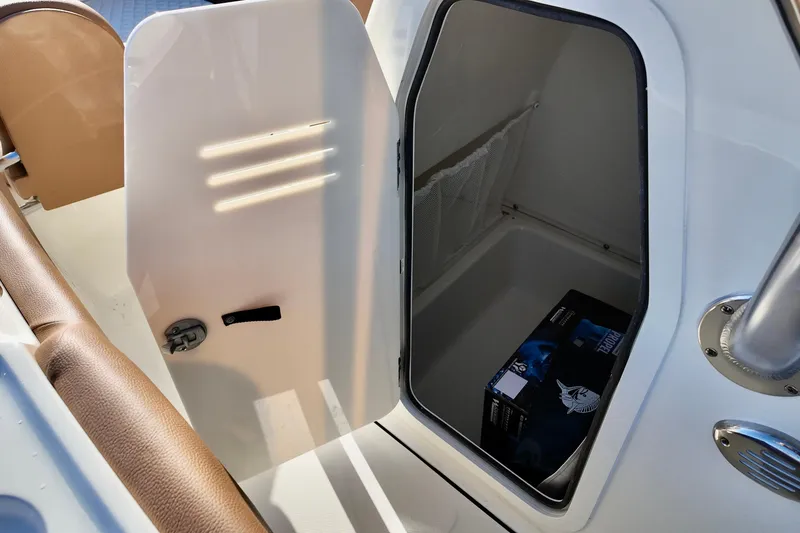Slide: The Image of Open storage compartment on 2026 Pioneer 202 Islander boat, showing interior space and a box. - 8