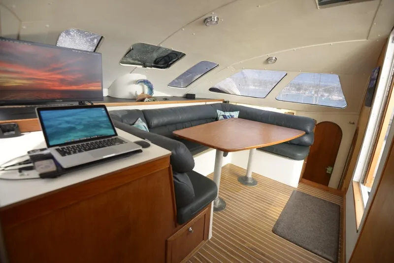 Slide: The Image of Interior of 1995 Lagoon TPI yacht with seating, table, and laptops. - 14