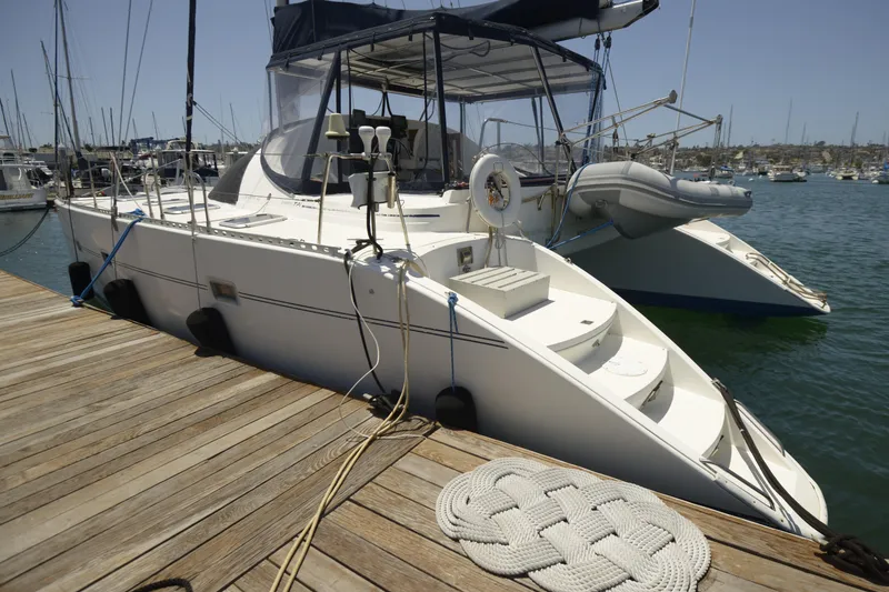 Slide: The Image of 1995 Lagoon TPI catamaran docked at marina, featuring sleek design and spacious deck. - 15