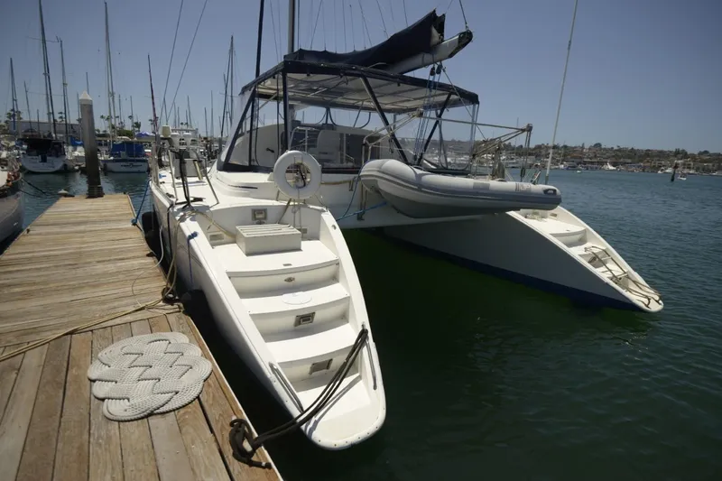 Slide: The Image of 1995 Lagoon TPI catamaran docked at a marina, featuring a spacious deck and mooring lines. - 16