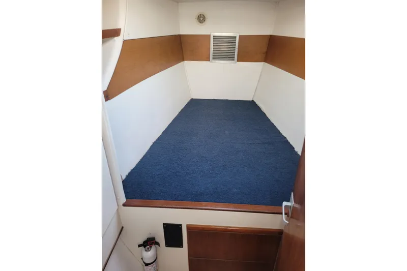 Slide: The Image of Interior cabin of 1995 Lagoon TPI boat with blue carpet and wooden accents. - 17