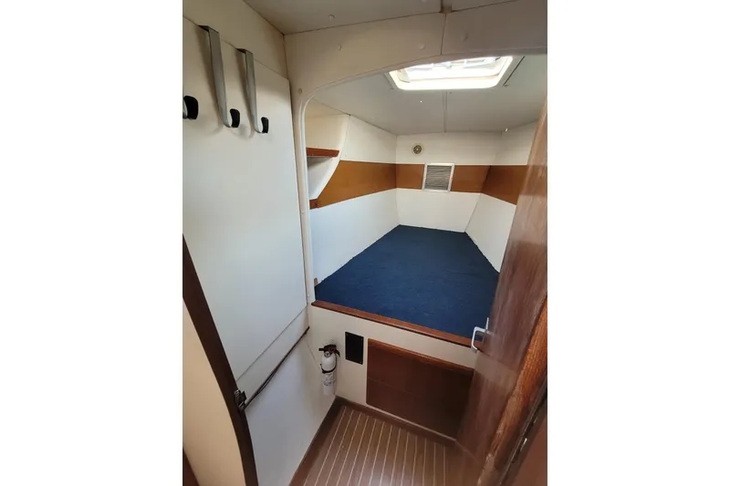 Slide: The Image of Interior cabin of 1995 Lagoon TPI boat with blue carpet and wooden accents. - 23