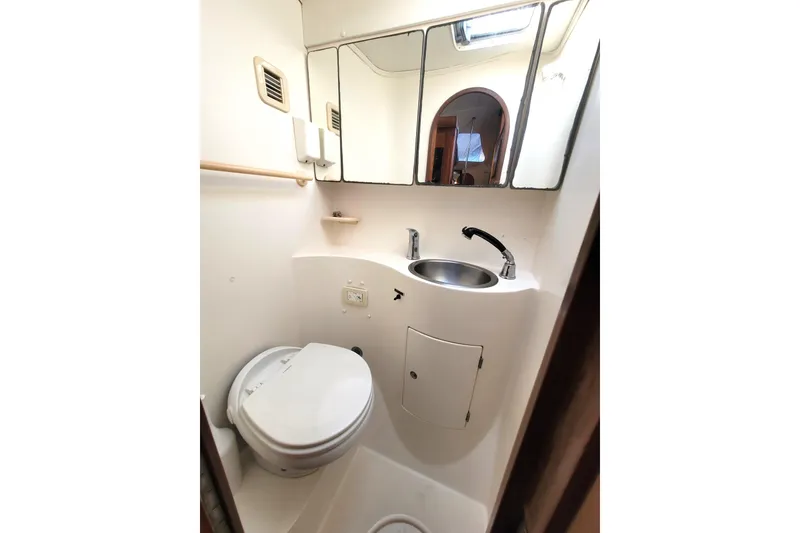 Slide: The Image of Compact bathroom in 1995 Lagoon TPI boat with toilet, sink, and mirror. - 25