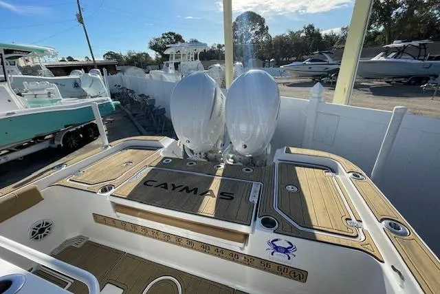 Slide: The Image of 2026 Caymas 291 HB boat with dual engines and teak deck in a marina setting. - 1