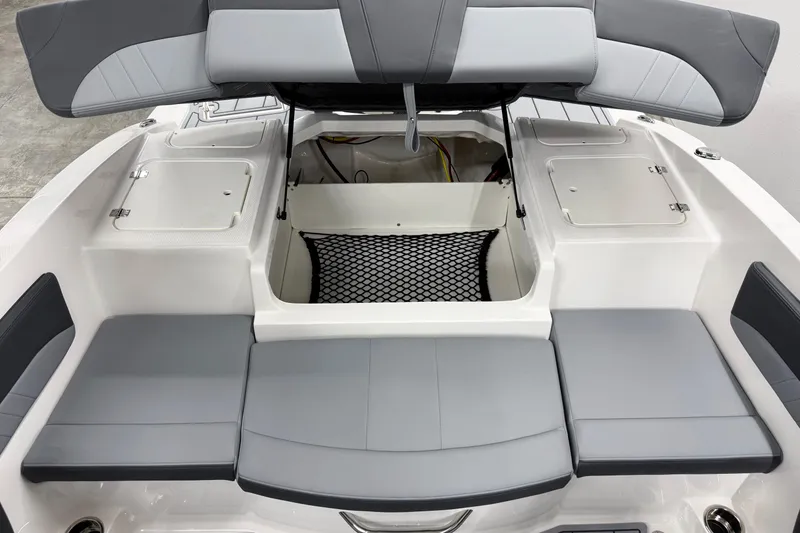 Slide: The Image of 2026 Chaparral 21 SSi OB boat interior with open storage compartment and cushioned seating. - 24
