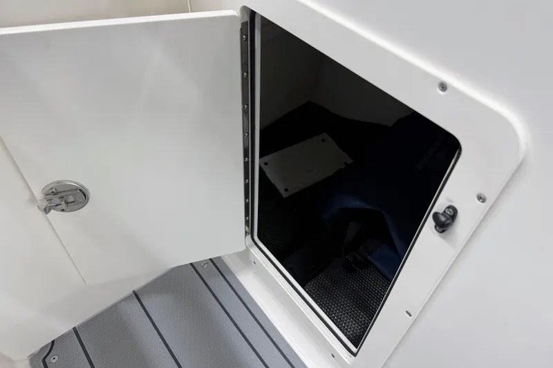 Slide: The Image of 2026 Chaparral 21 SSi OB boat storage compartment with open door. - 28