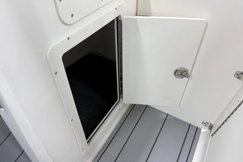 Slide: The Image of Open storage compartment on 2026 Chaparral 21 SSi OB boat, featuring sleek white interior design. - 29