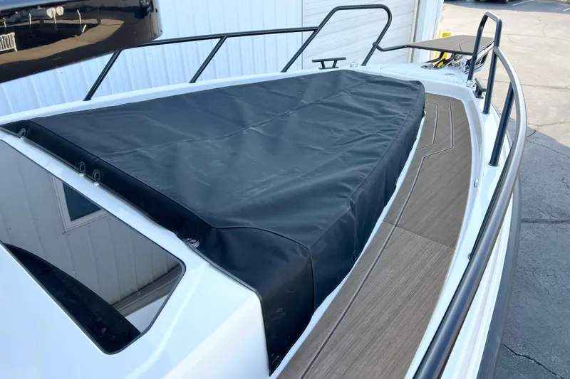 Slide: The Image of Navan C30 2026 boat with black cover and wooden deck, docked near a building. - 11