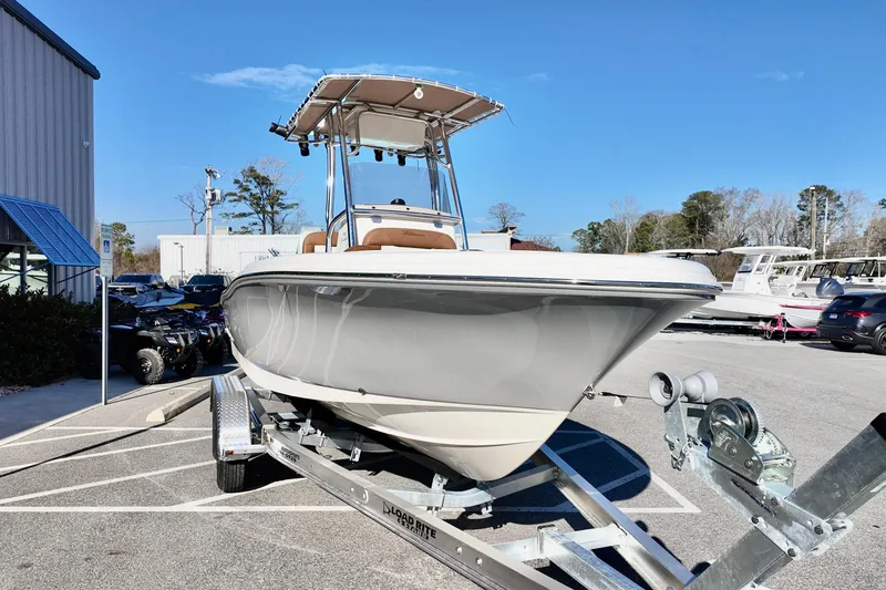Slide: The Image of 2026 Pioneer 202 Sportfish boat on trailer, parked outdoors under clear blue sky. - 2