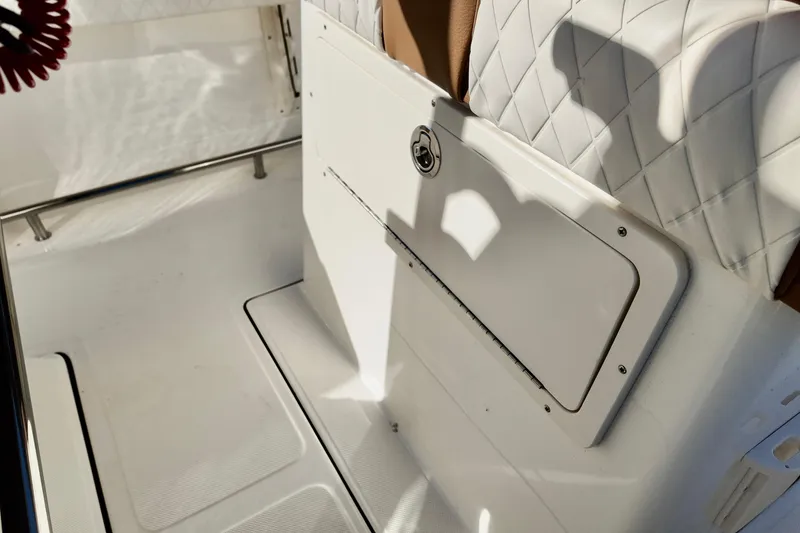 Slide: The Image of Interior of 2026 Pioneer 202 Sportfish boat, featuring white seating and storage compartment. - 5