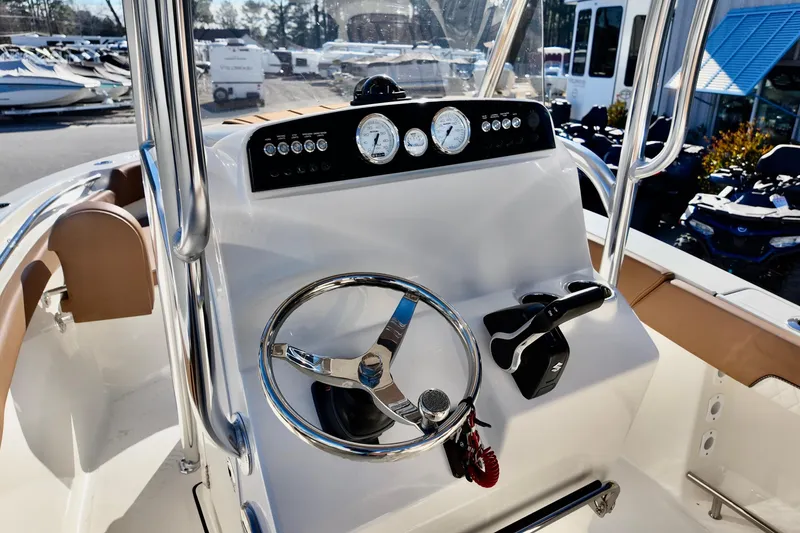 Slide: The Image of 2026 Pioneer 202 Sportfish boat dashboard with steering wheel and controls. - 8
