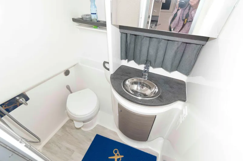 Slide: The Image of Compact bathroom in 2019 Formula 34 Performance Cruiser with sink, toilet, and mirror. - 23