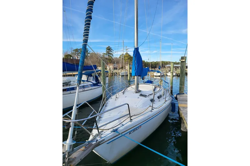 Slide: The Image of 1982 Catalina 30 sailboat docked in a marina, clear blue sky. - 10