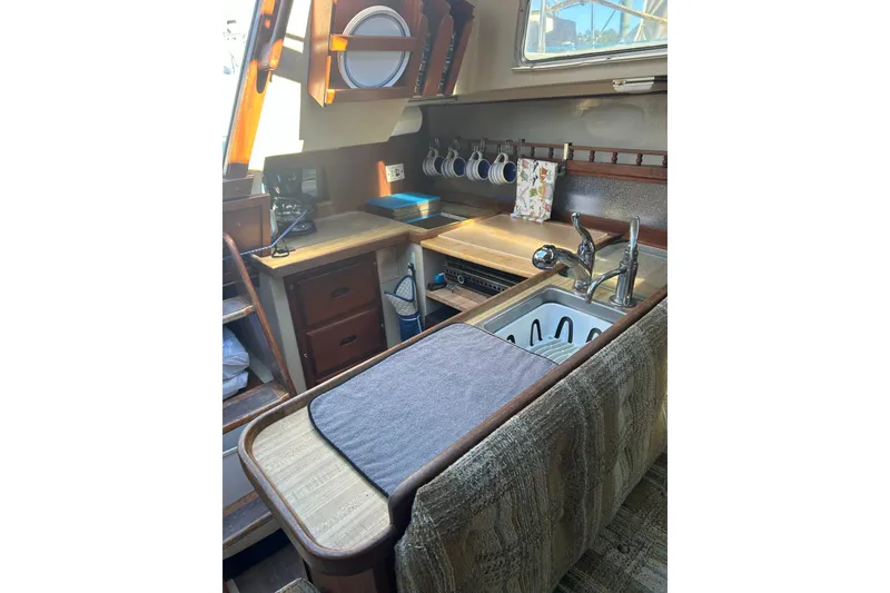 Slide: The Image of Interior of 1982 Catalina 30 sailboat kitchen with sink, stove, and storage. - 7