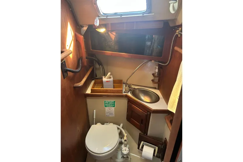 Slide: The Image of Compact bathroom in 1982 Catalina 30 sailboat with toilet, sink, and storage. - 8